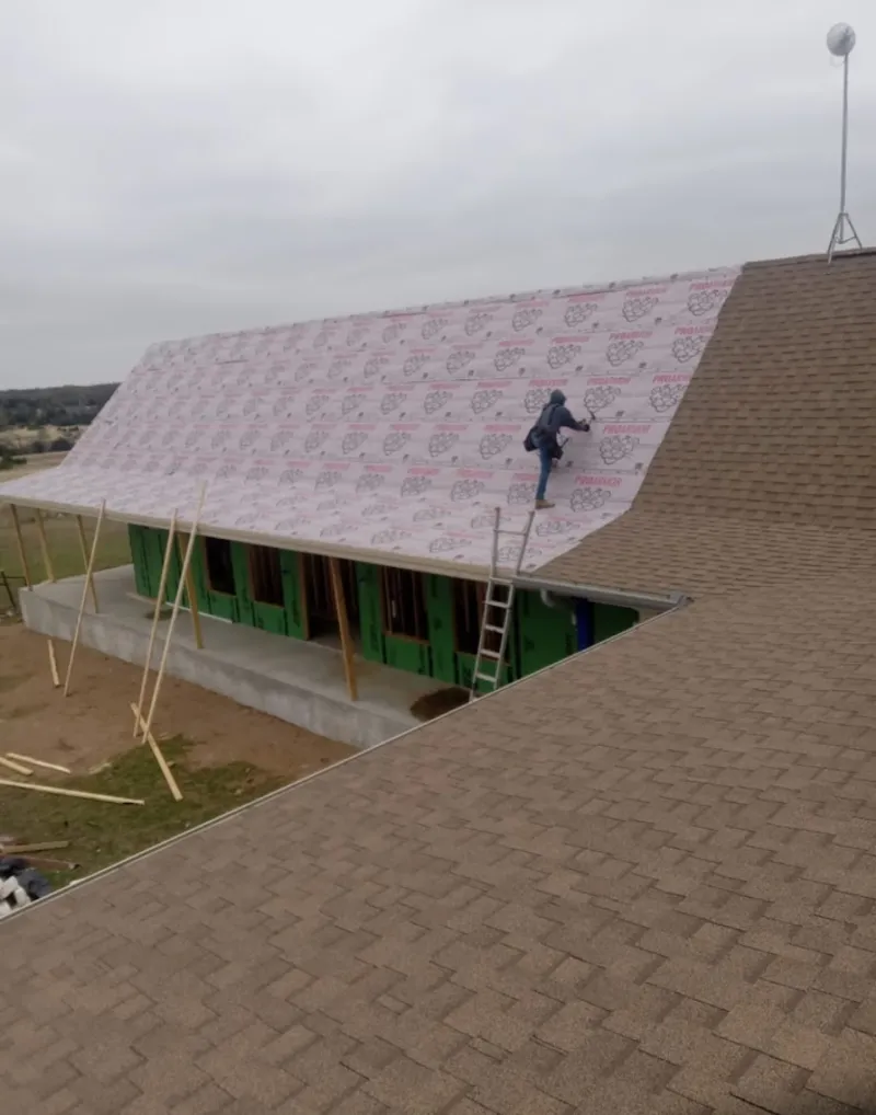 Worker preparing underlayment for a metal roof installation in Twentynine Palms